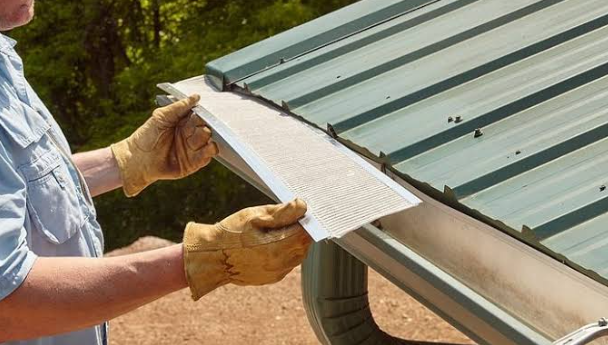 Installer holding a gutter guard panel ready to fit onto a gutter