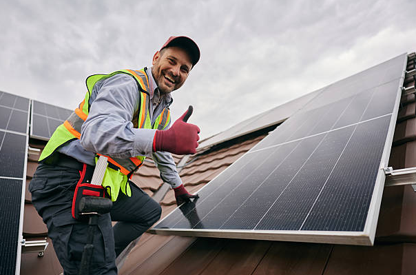 Perfect Pane crew working carefully around wiring and mounts on a rooftop solar array