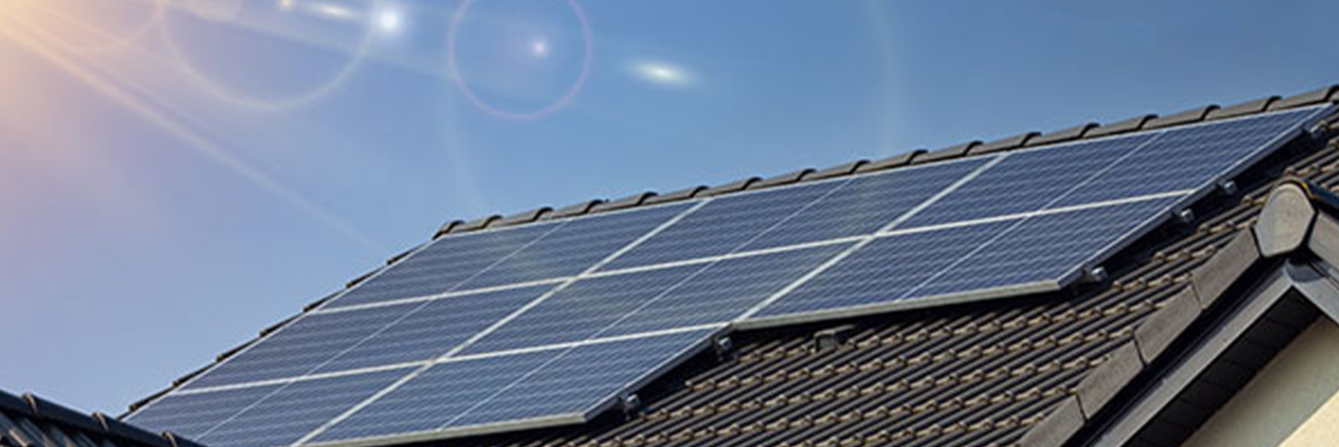 Residential rooftop solar array against a blue sky