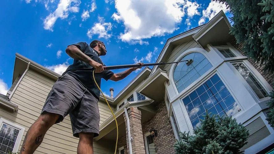 Perfect Pane technician cleaning windows on a large residential home in Vallejo