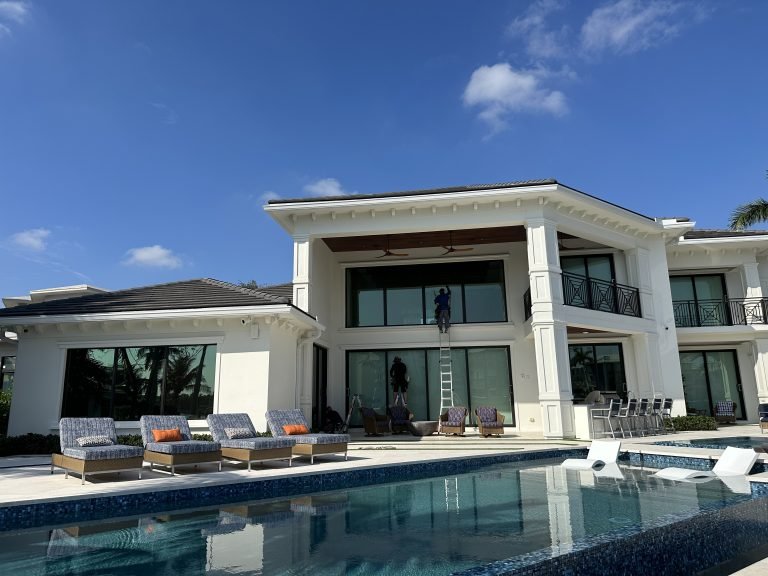 Perfect Pane technician cleaning second-story windows on a home with a pool in Vallejo & the North Bay