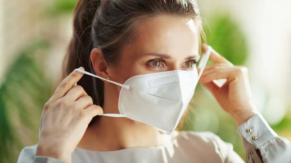 Technician putting on a protective face mask before entering a home